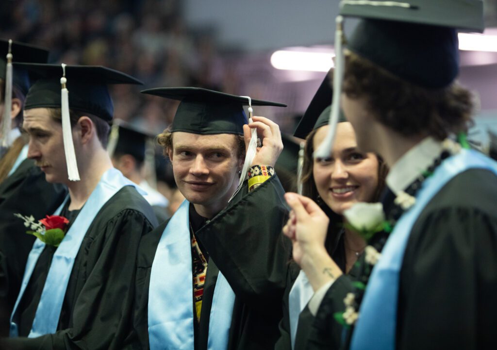 Graduates finish turning their tassels.