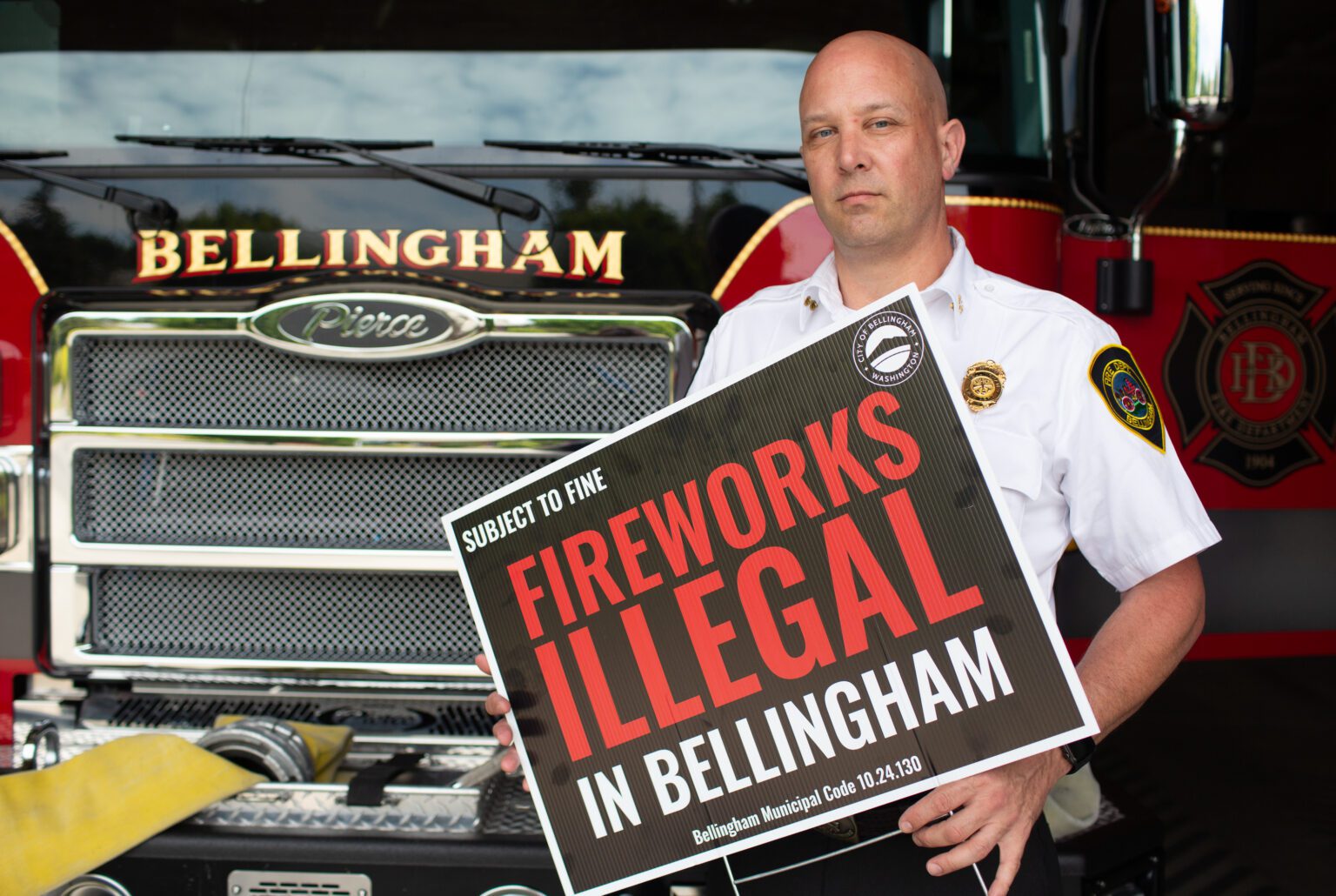 Bellingham Assistant Fire Chief Dave Pethick holds a sign warning people of using fireworks in Bellingham.