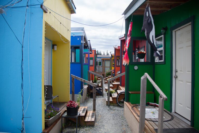 A path in between twenty colorful tiny homes fill Unity Village.