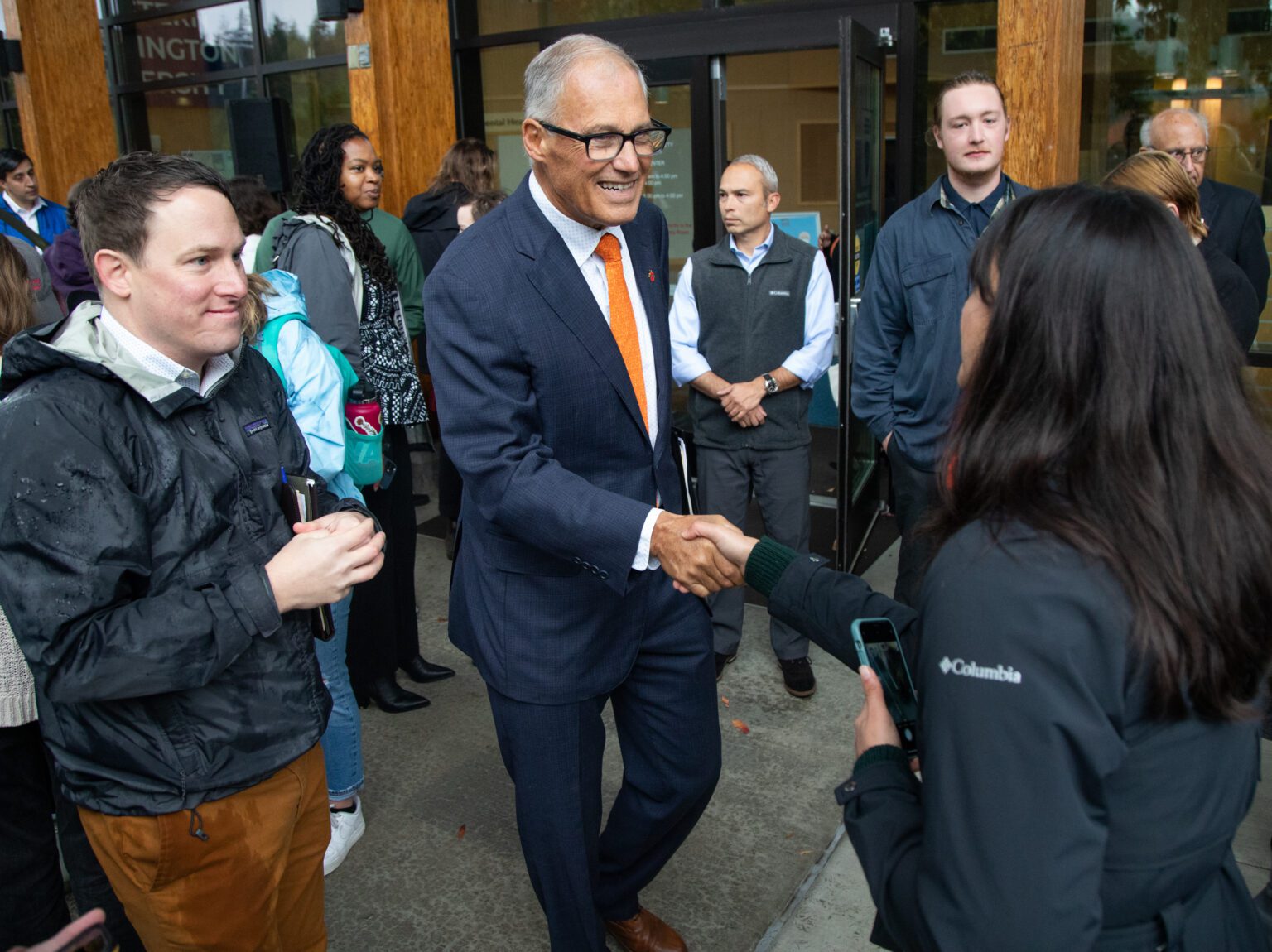 Gov. Jay Inslee shakes hands with audience members at the end of the press conference.