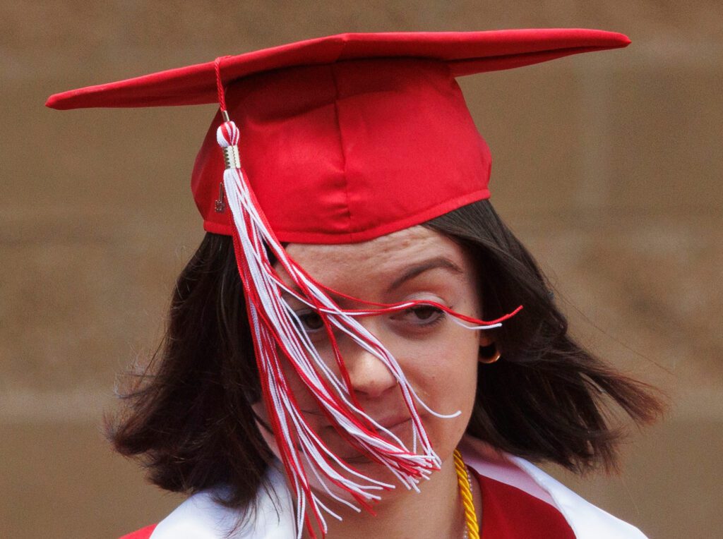 A tassel gets caught on a Bellingham graduate's eyelashes as it is blown by wind.