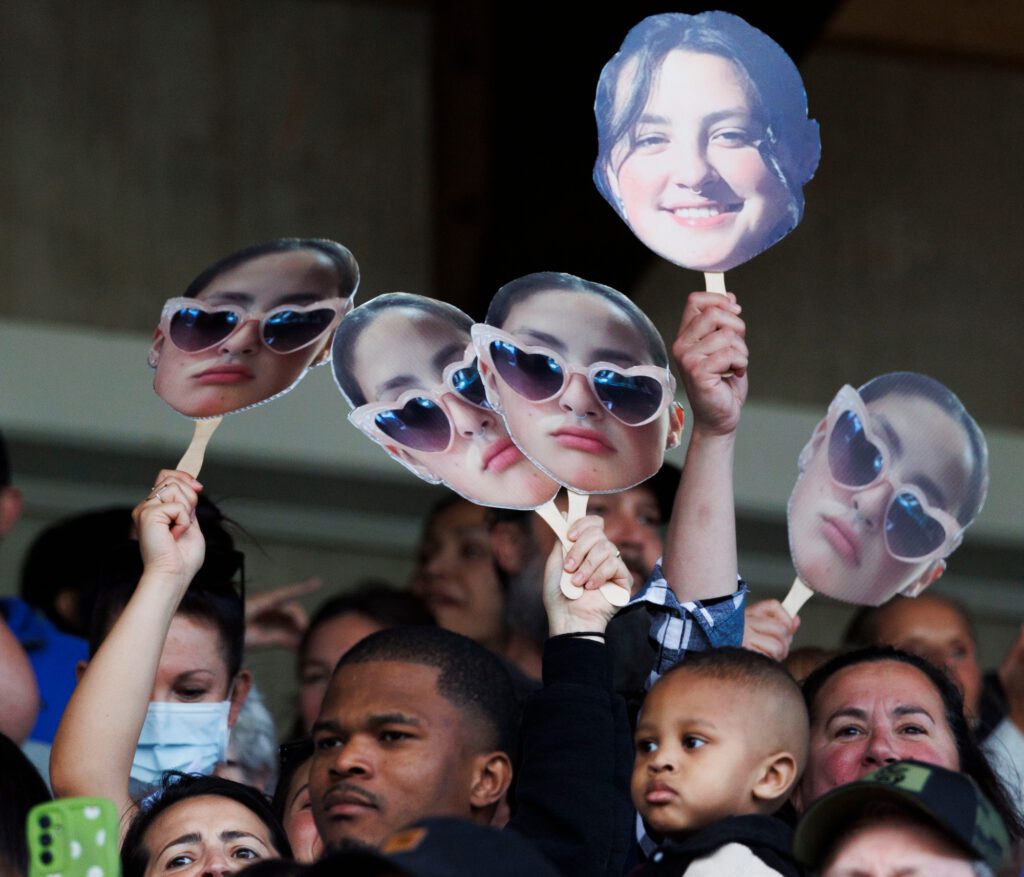 Family members holds up pictures of Bellingham graduate Angelina Bellefeuille at the start of the ceremony.