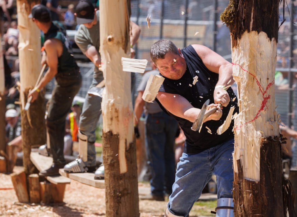 Chips fly as Brandon Harkness competes in the pole falling competition.