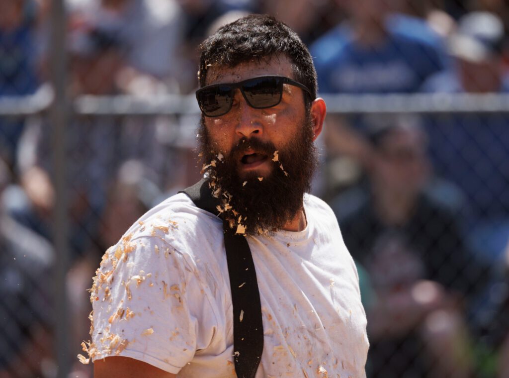 Dane Stemme is covered in sawdust after diving at a bumper during the wrapper-throwing competition.