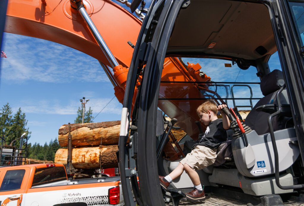 Luke Johnson, 3, tries to reach the foot pedals while playing on heavy equipment.