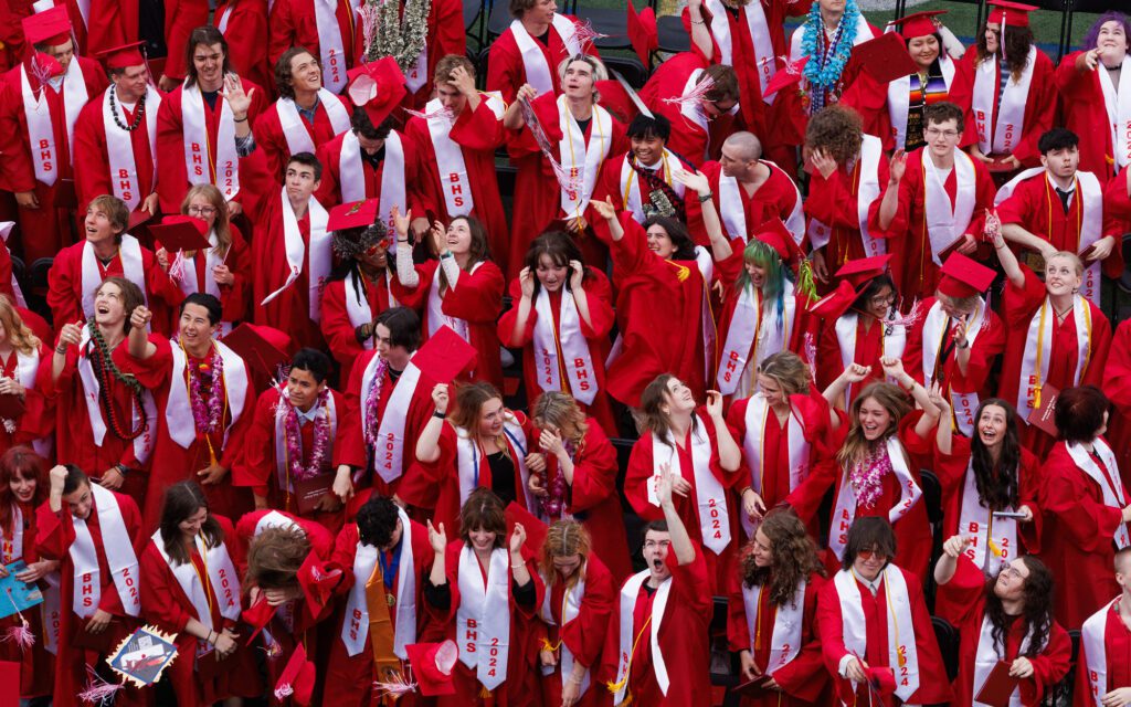 Bellingham High School graduates toss their mortarboards in the air.