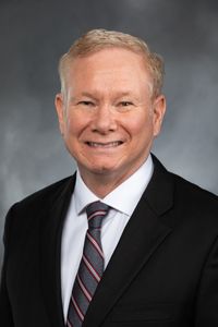 A white man wearing a suit and tie