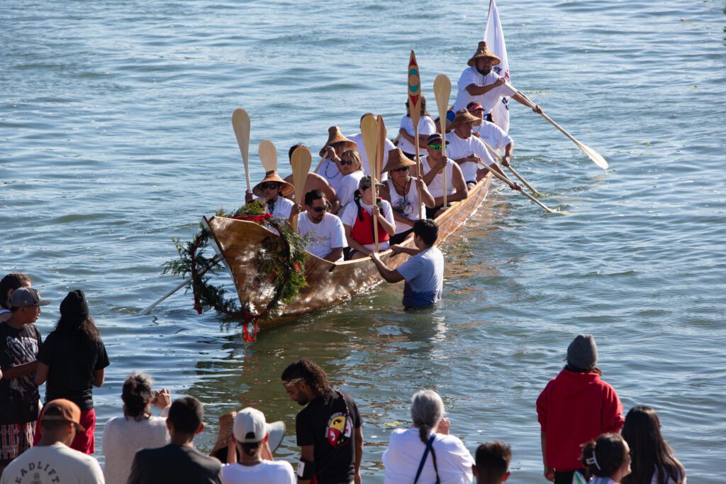 Members from Sts'ailes, a Coast Salish First Nation, arrive to the shore.