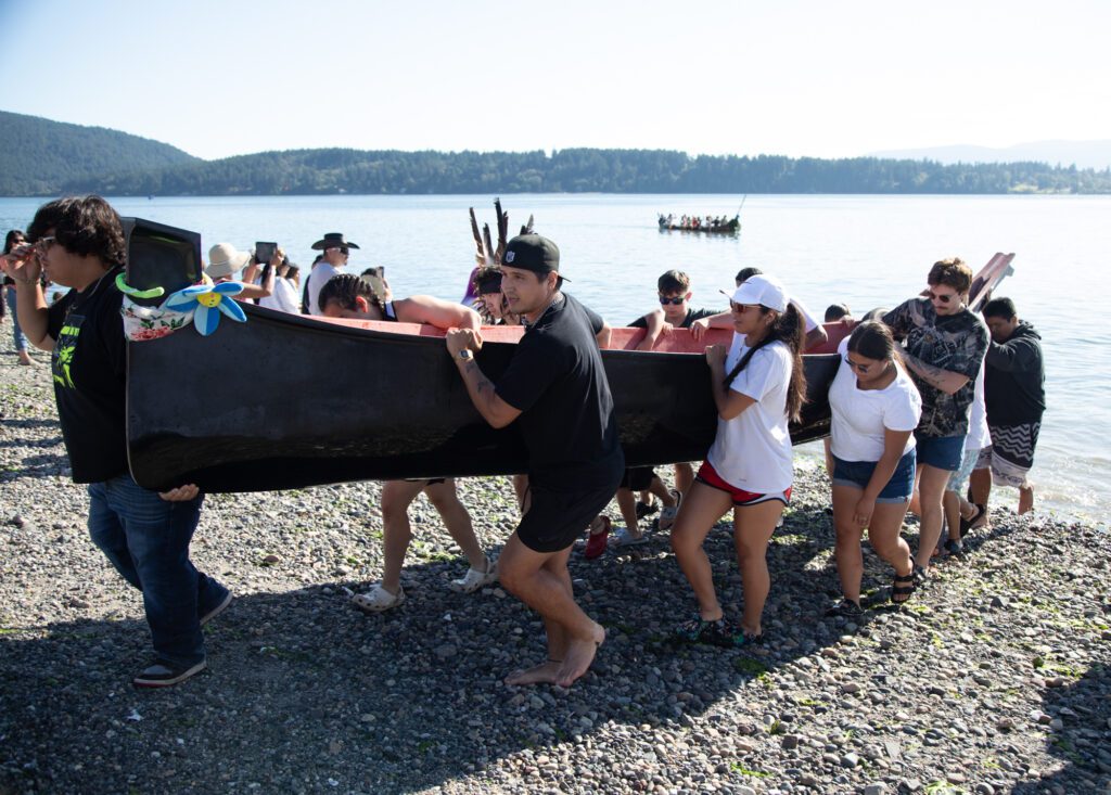 A canoe is carried out of the water.