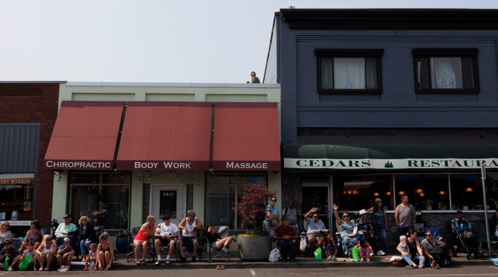 A spectator finds a rooftop to watch the grand parade.