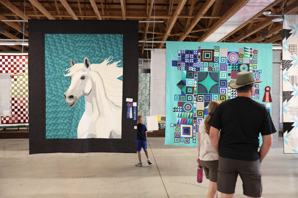 Quilts hang in the exhibition hall.