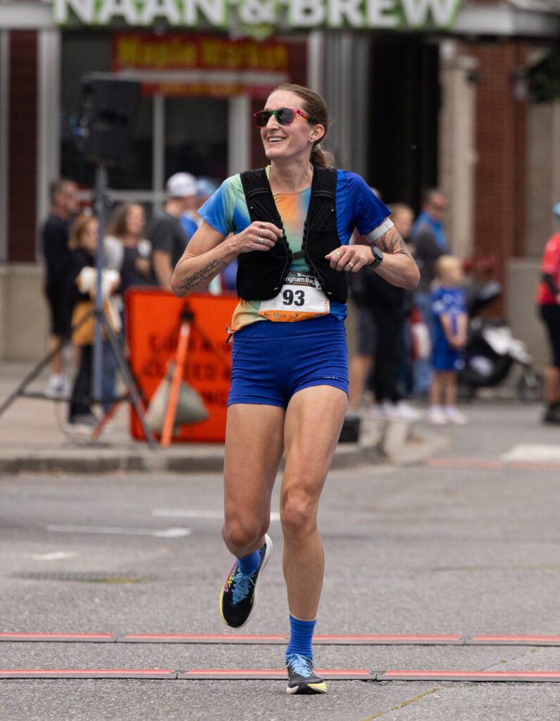 Courtney Olsen smiles while crossing the finish line after a 2:47:19 run, good for first place in the female divison.