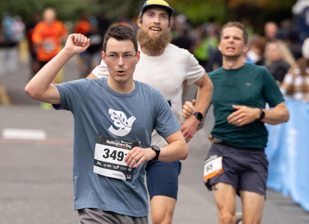 Kyle Lincoln puts his fist in the air after finishing the 5K.