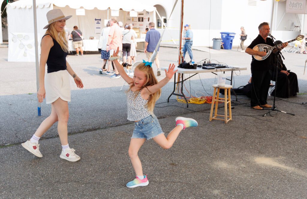 Kennedy McQuaig kicks her heels and arms as she dances with her mother Kourtnei Sept. 7 during the Bellingham Greek Festival at St. Sophia Greek Orthodox Church in Bellingham.