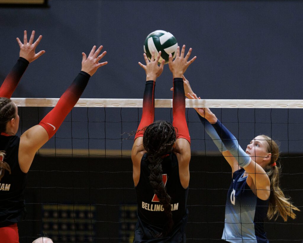 Lynden Christian’s Etta DeJong sends the ball over two Bellingham blockers