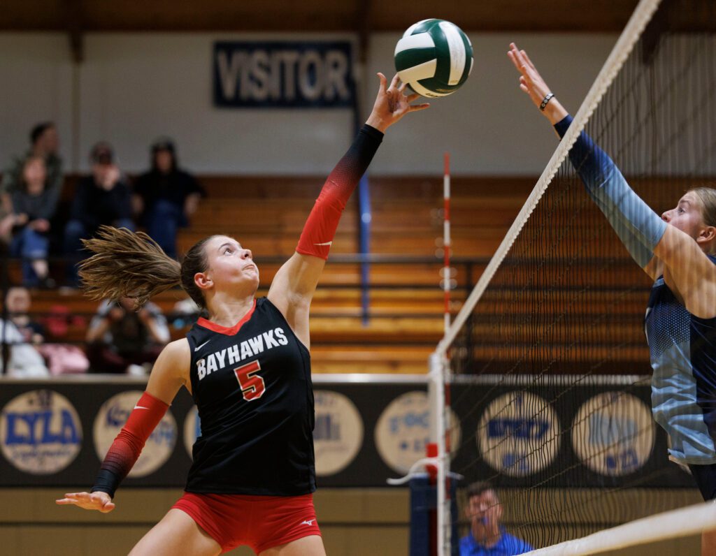 Bellingham’s Sonoma Smith reaches up for the ball against  a Lynden Christian blocker.