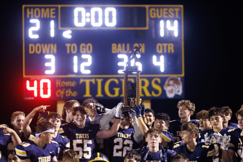 Burlington-Edison players celebrate with the Battle of the Bridge trophy after Friday’s game against Mount Vernon.