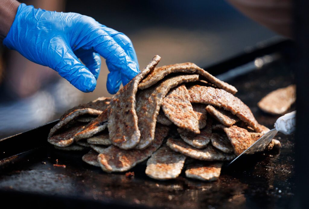 Strips for gyros are piled high on a grill.