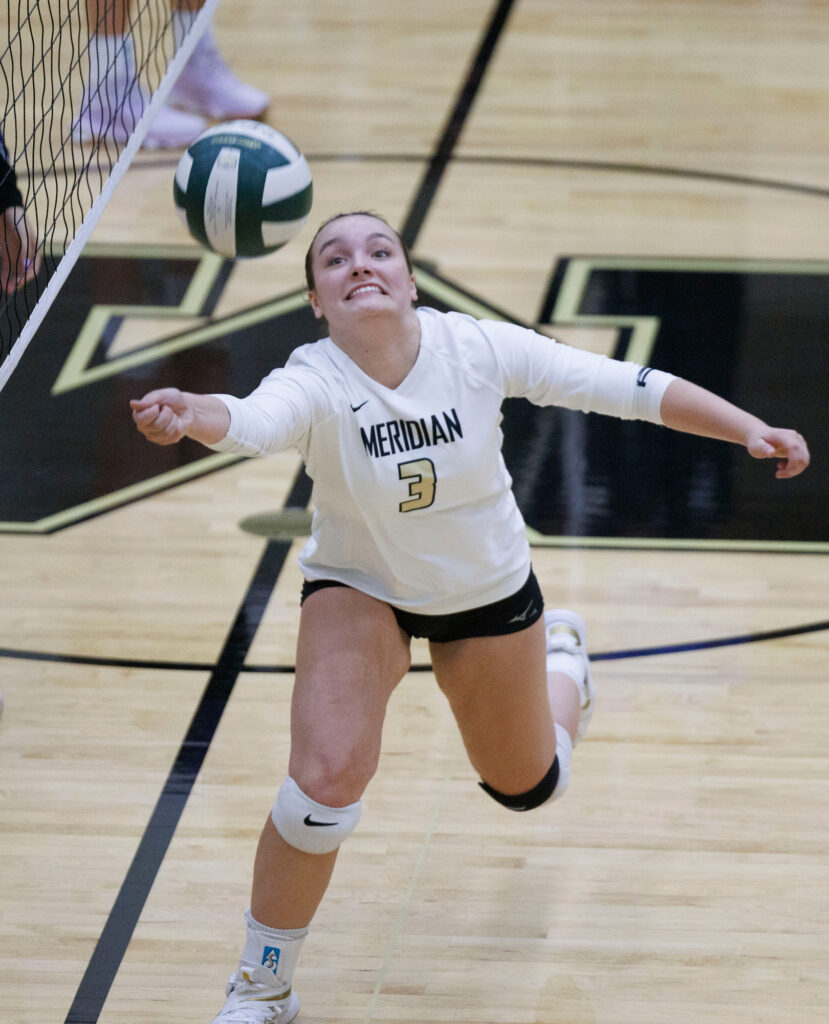 Meridian’s Grace Wells reaches to keep the ball in play during the fifth set.