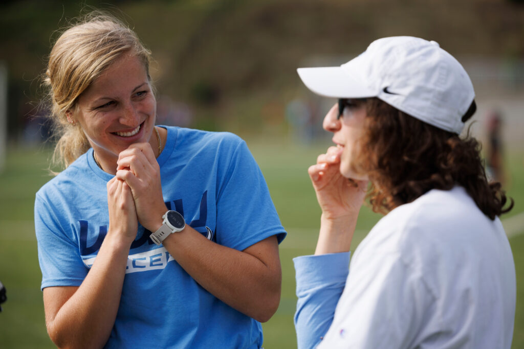 Former tammates Claire Henninger and Chloe Unfelt laugh and chat during an interview as the 2016 and 2022 national championship women's soccer teams were honored at halftime of the Western Washington and Western Oregon soccer game.