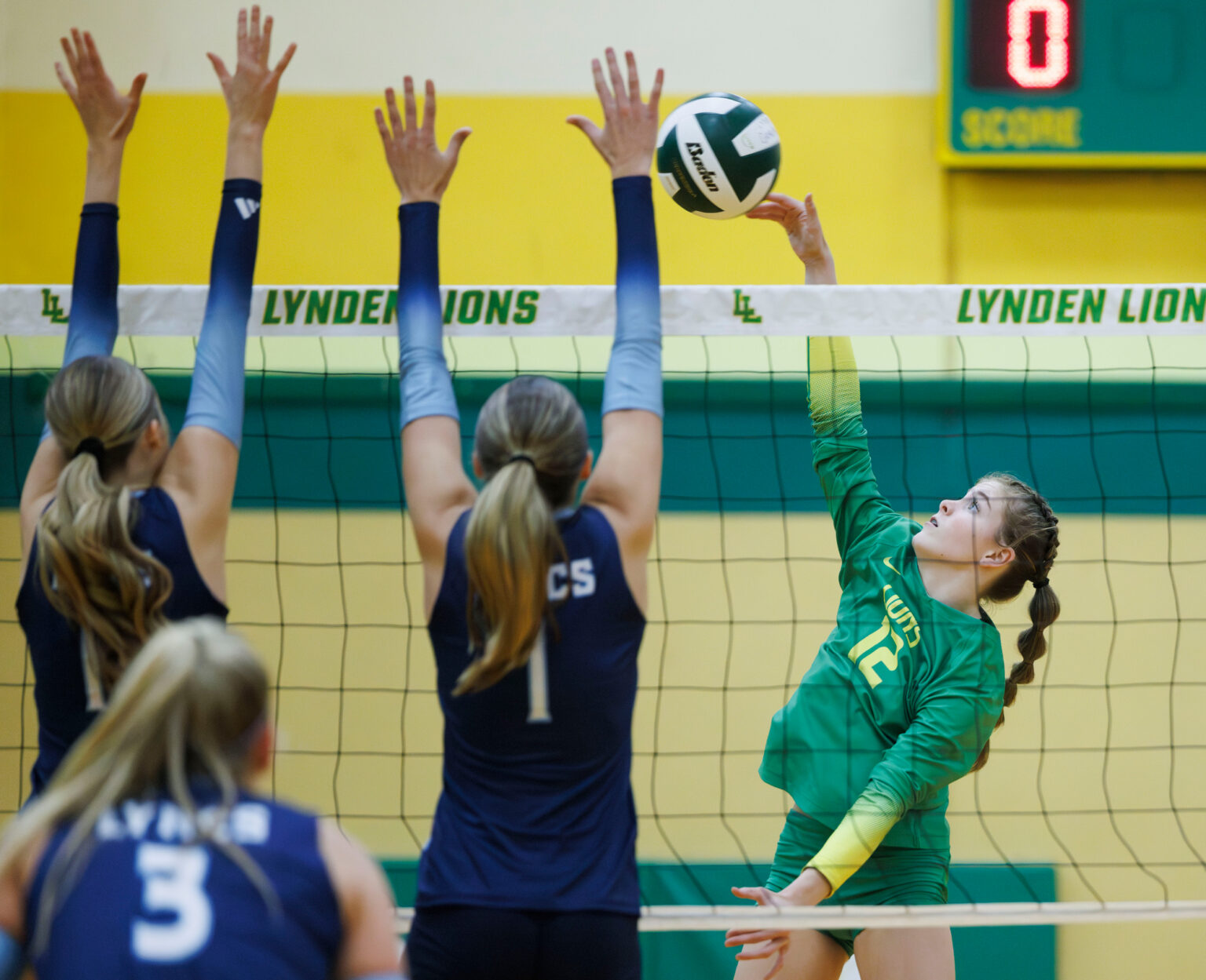 Lynden’s Sarah McVie spikes against two Lynden Christian blockers.