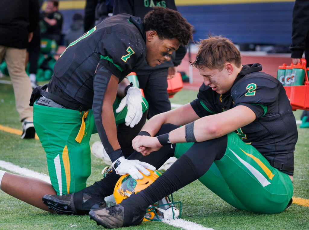 Lynden’s Brant Heppner is consoled by teammate Lynden’s Zay Harris Saturday, Nov. 23 after the Lions lost to Archbishop Murphy 10-9 in the 2A state quarterfinals at Ferndale High School.