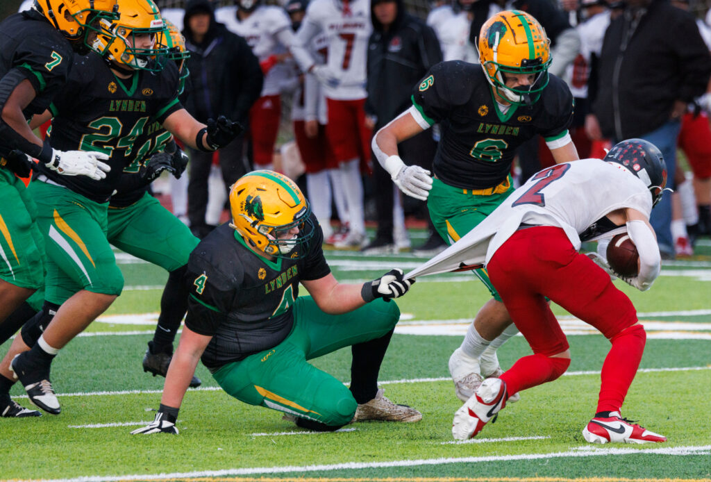 Lynden’s Jax Baar holds the jersey of an Archbishop Murphy player as Lynden’s Lofa Tigilau comes in for the tackle.