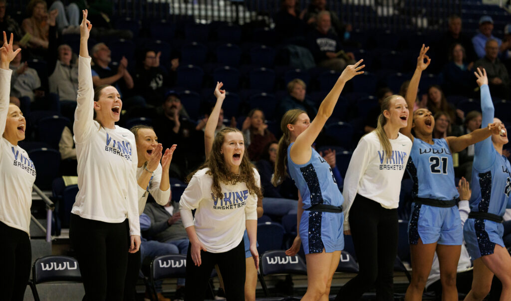 Western's bench cheers as teammate Mason Oberg hits a 3-pointer.