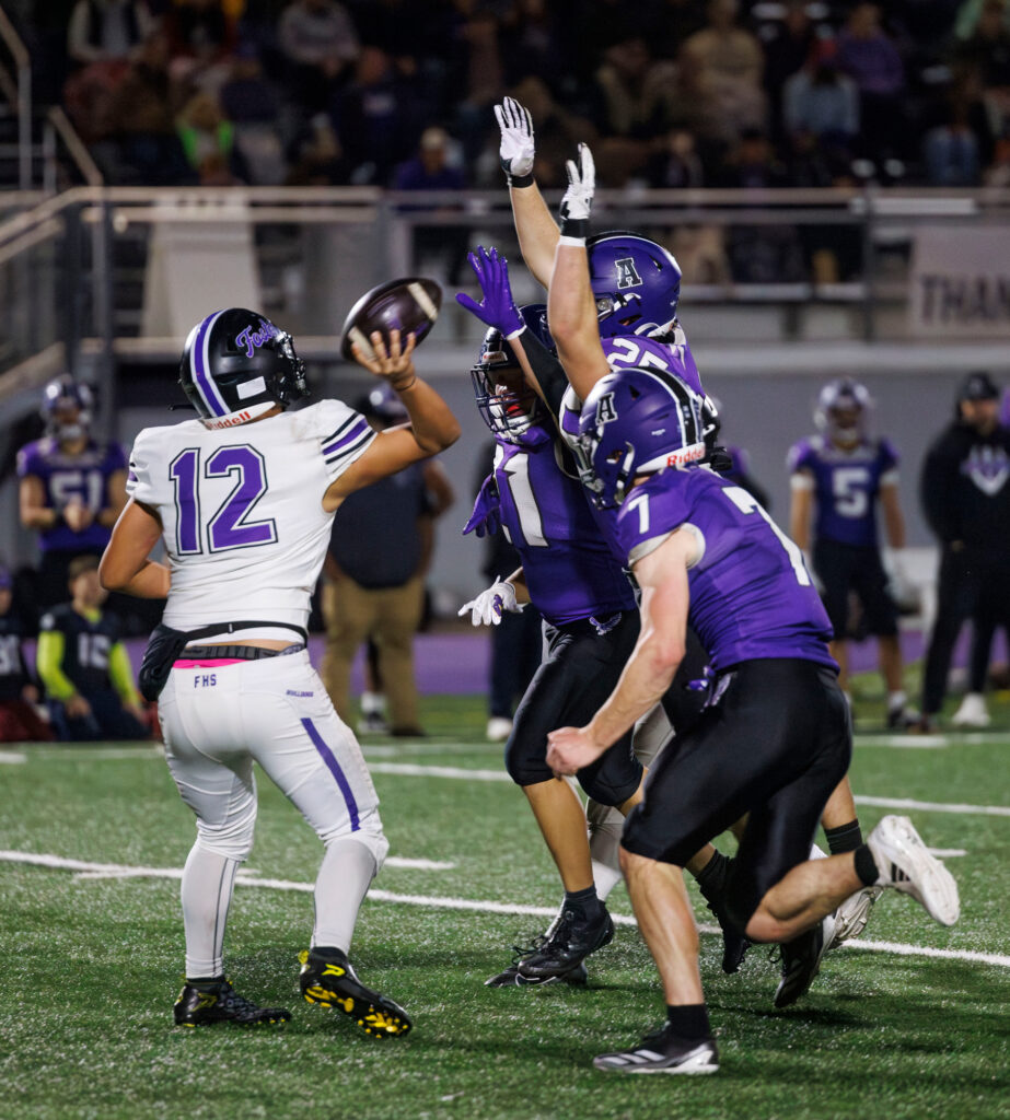 Three Anacortes defender pressure Foster's quarterback into throwing a pick-six.