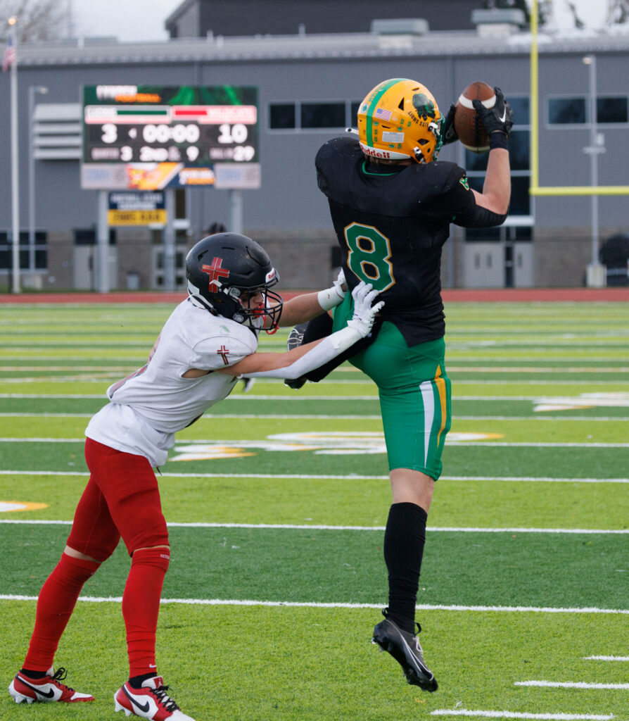 Lynden’s Isaiah Oudman haul in a pass as an Archbishop Murphy defender tries to shove him out of bounds on the play .