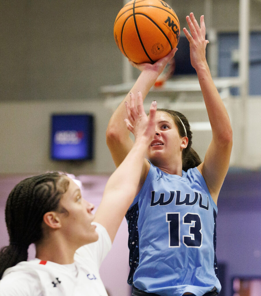 Western guard Demi Dykstra takes her shot as a Cal State East Bay player tries to block her vision.