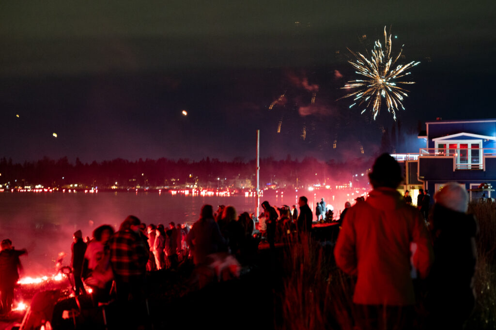 Fireworks fly over Birch Bay as the coast glows red with flares along the Bay Breeze Restaurant and Bar.