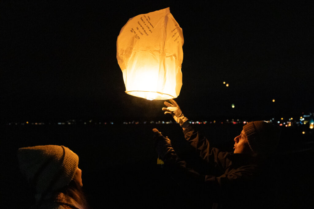 Kelly, left, and Eric Savela release a lantern with messages to loved ones into the sky.