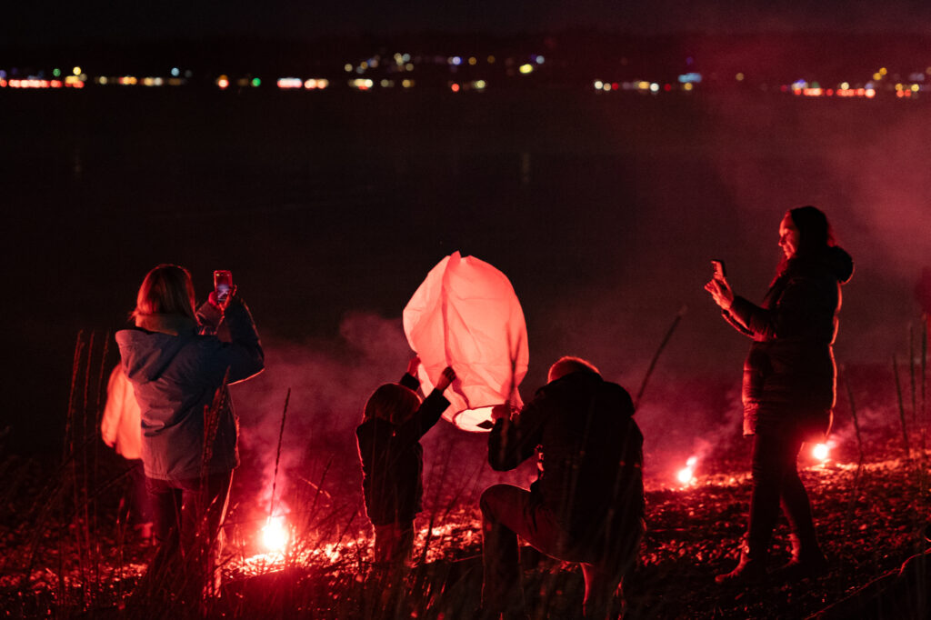 A family lights a lantern and takes photos.