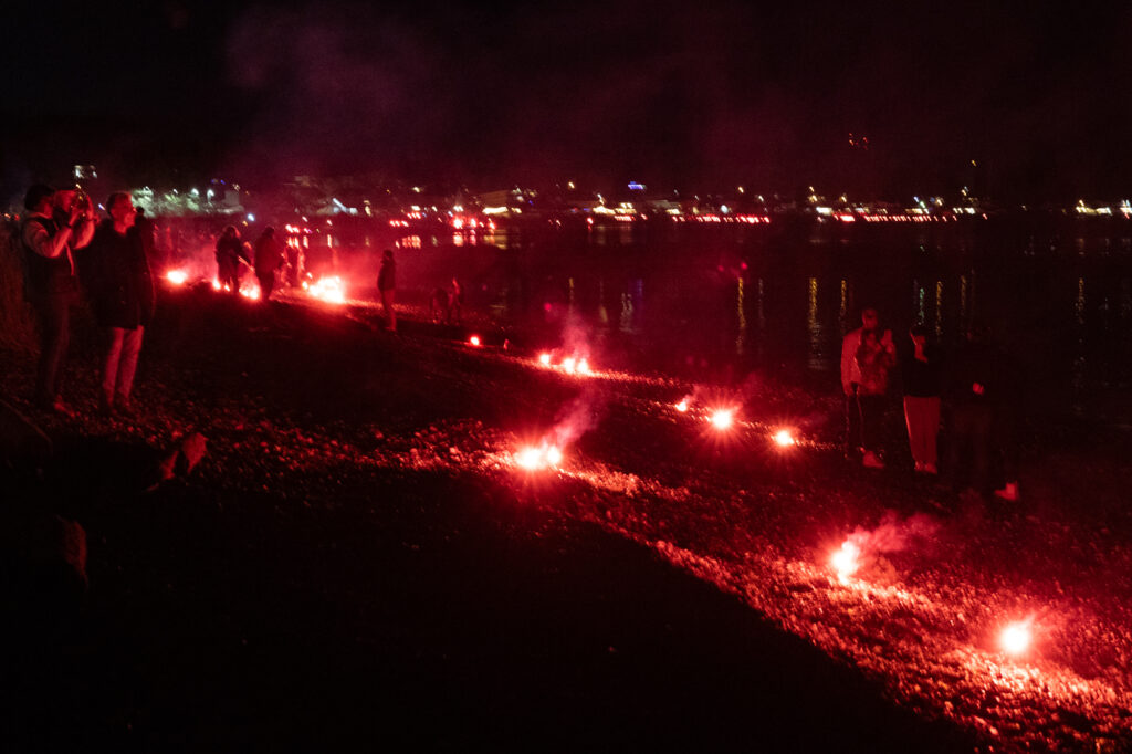 Dozens of flares line the beach, looking south.