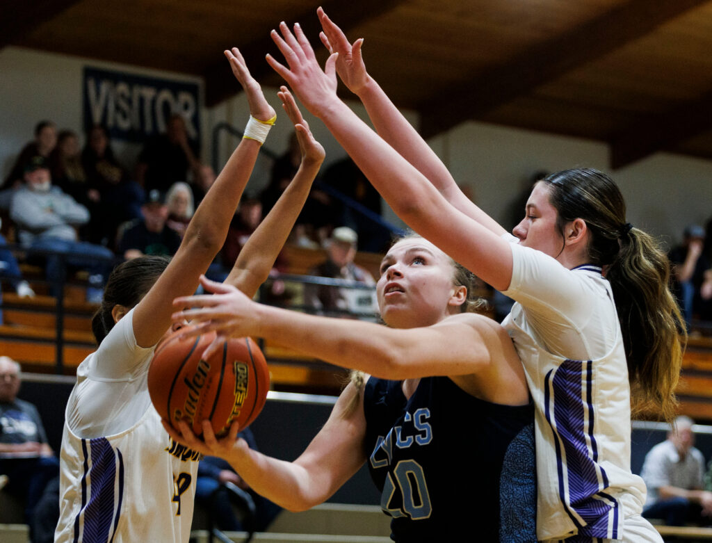 Lynden Christian’s Allison Shumate goes for the basket under pressure from Issaquah defenders.