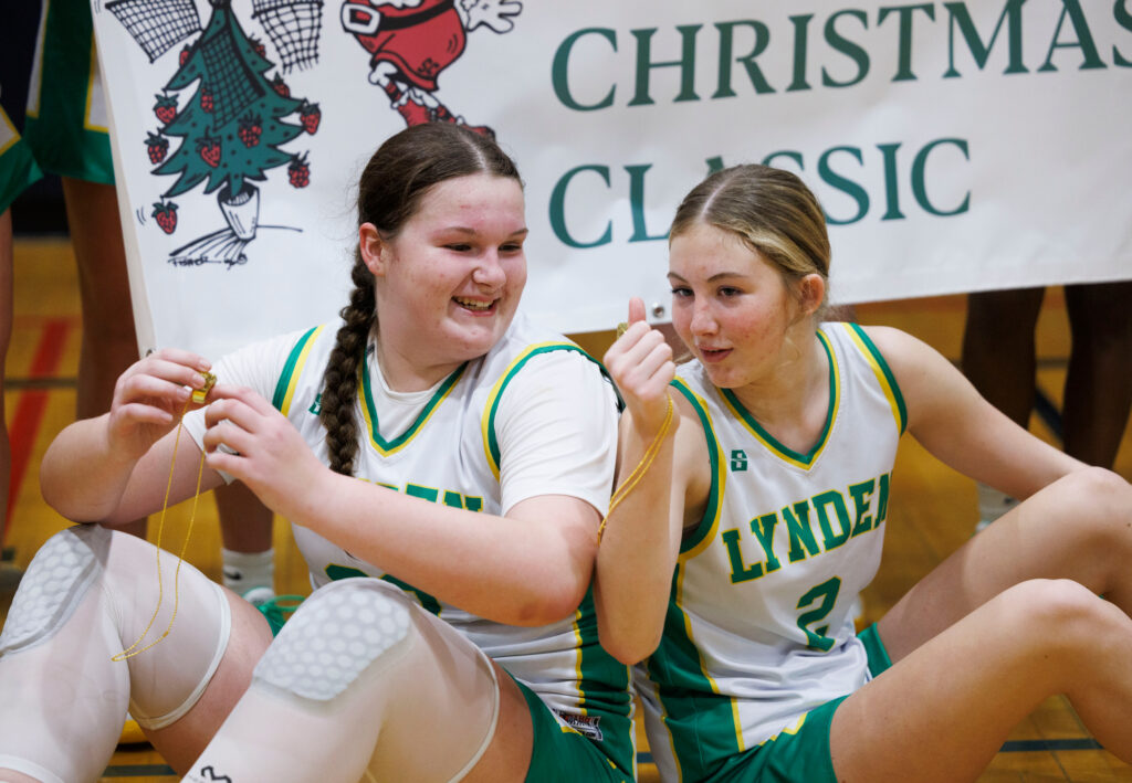 Lynden’s Payton Mills and Lexie Hermanutz look over the winner’s rings after beating White River in the title game.