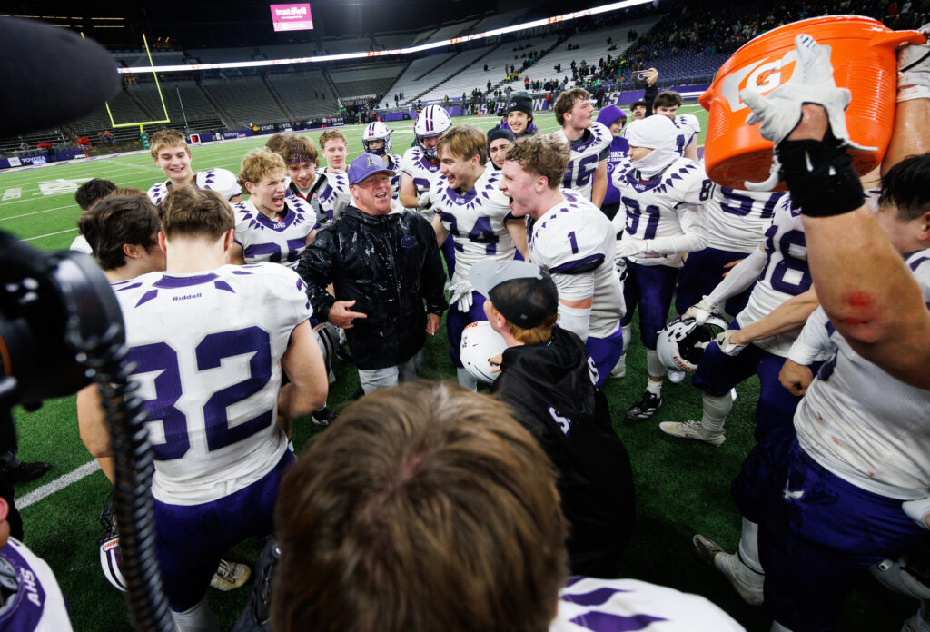 Players celebrate after dumping water on Anacortes head coach Justin Portz.