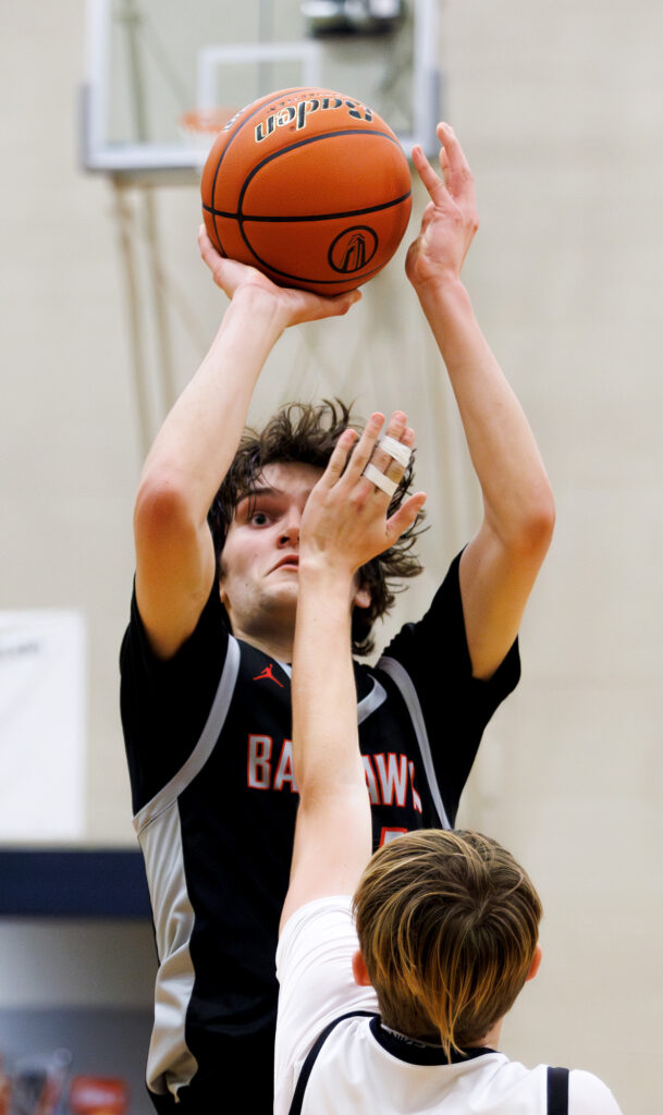 Bellingham’s Kincade Vanhouten shoots a 3-pointer with a hand in his face.