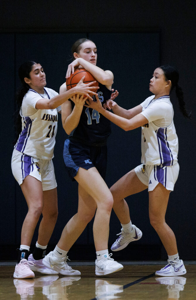 Lynden Christian’s Alisa Scott fights for the ball against two Issaquah defenders.