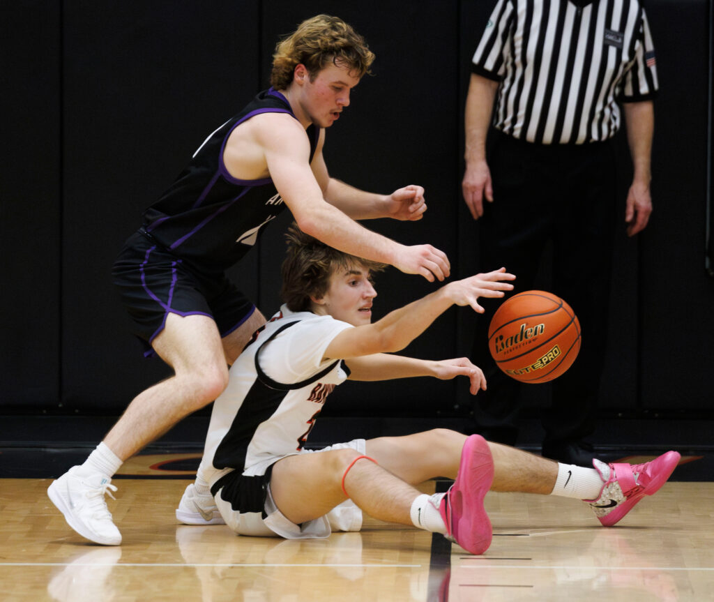 After falling to the floor, Bellingham’s Myllo Wright reaches for the loose ball as Anacortes’ Jake Andrew reaches from above him Dec. 19.