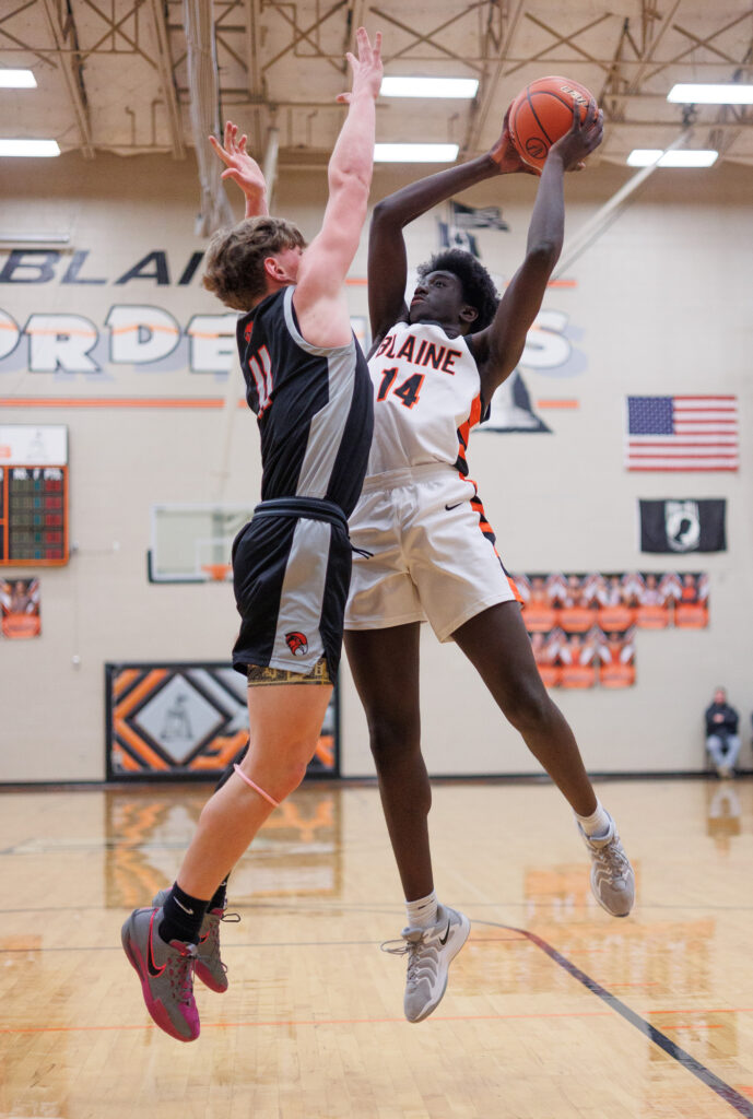 Blaine’s Dulio Kanagie takes a jump shot as Bellingham’s Joe Harward leaps up for an attempt to block it.