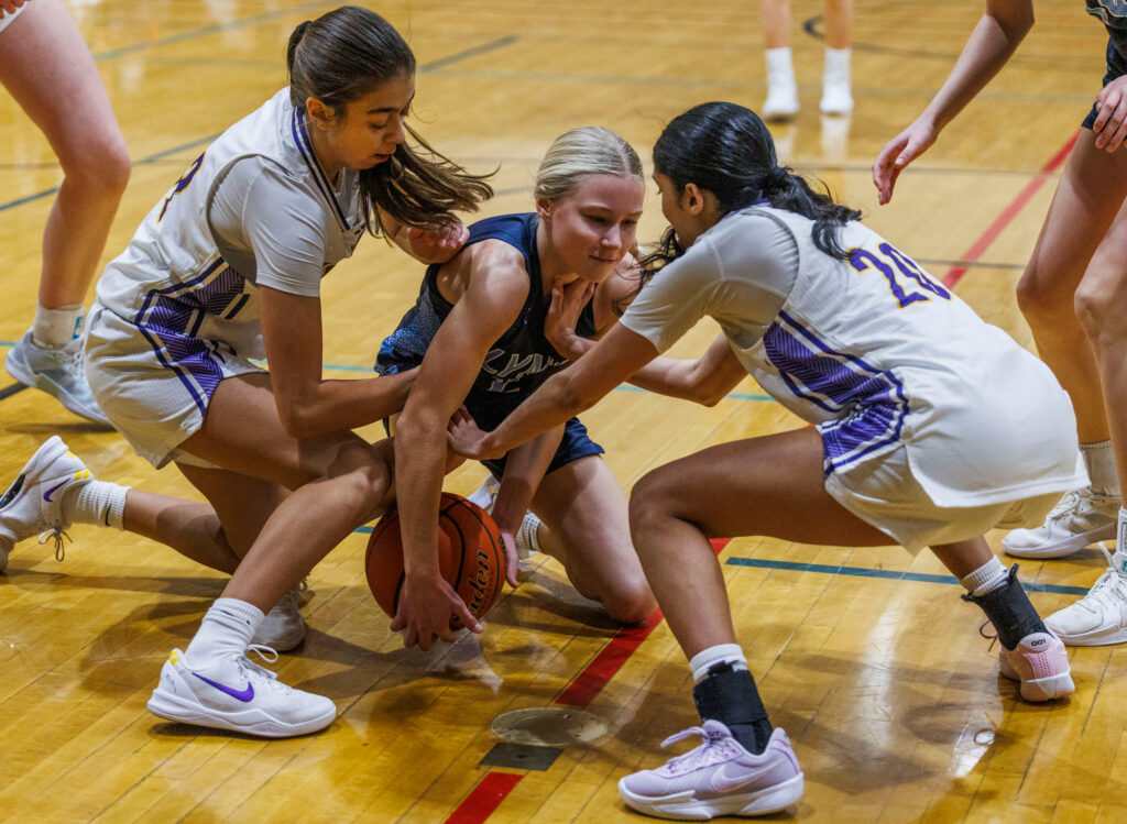 Lynden Christian’s Tyra Dykstra battles for the loose ball with two Issaquah defenders.