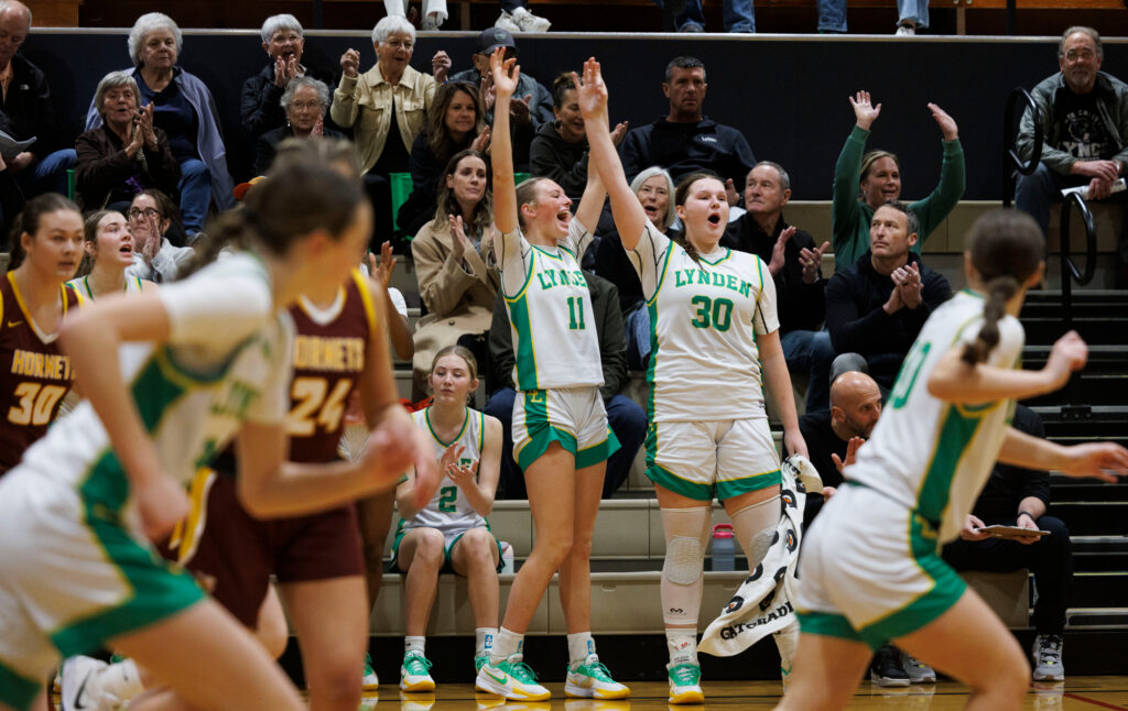 Lynden’s Rian Stephan and Payton Mills stand up and cheer after a 3-point shot by Rilanna Newcomb late in the game.