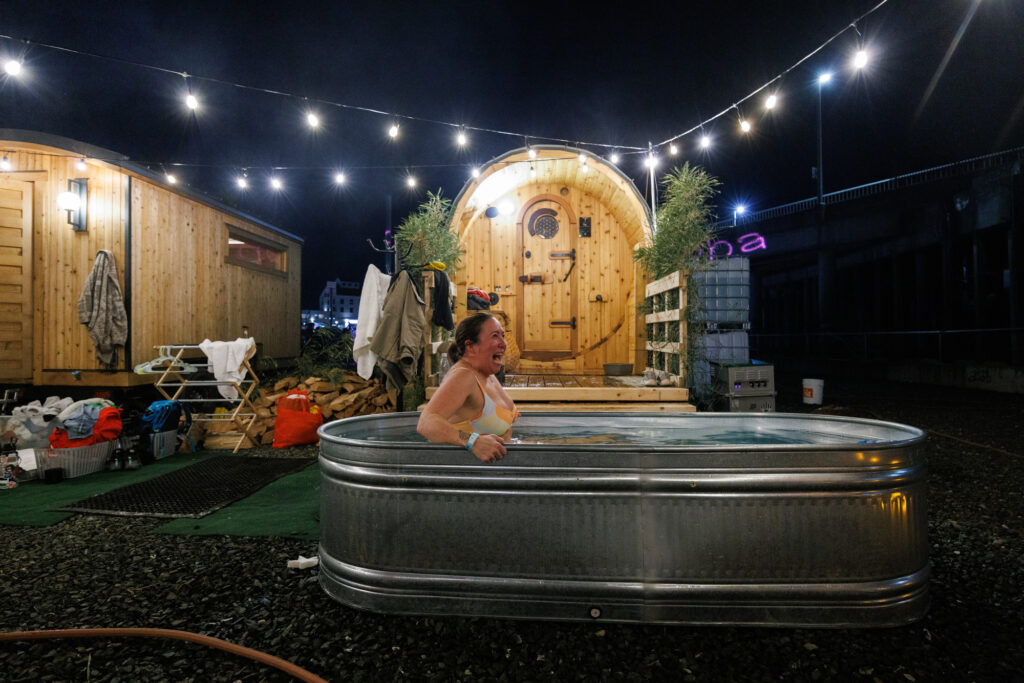 After a hot sauna, Jen Newbauer reacts as she dips into a cold tub at the Sauna Grove.