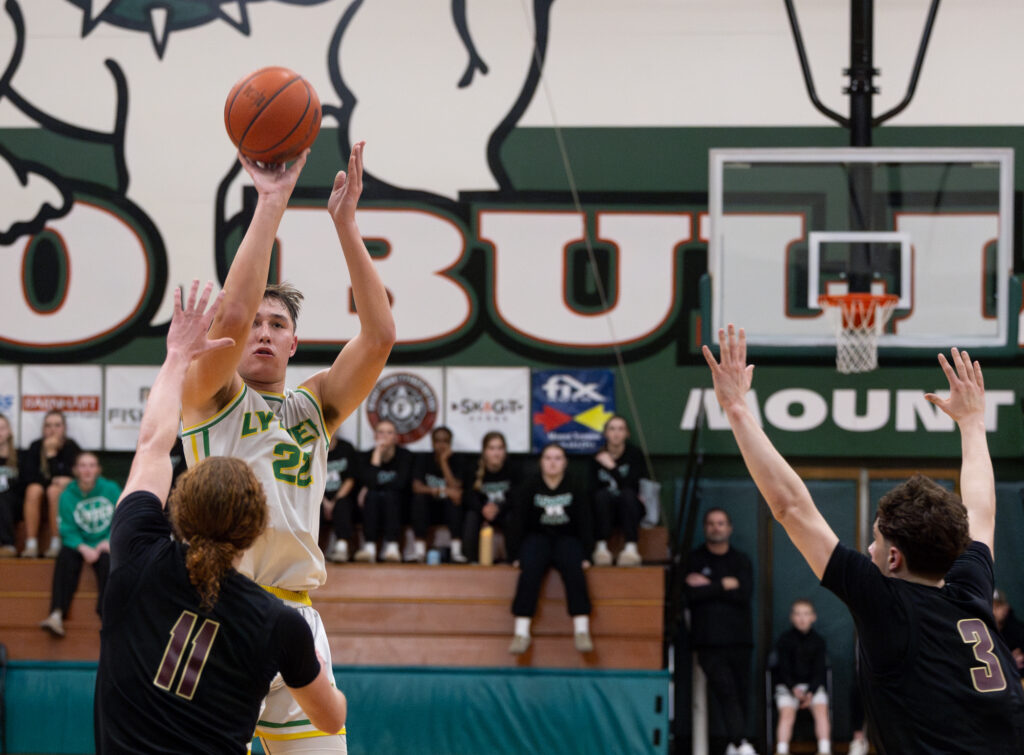 Defenders close in on Lynden senior guard Brant Heppner as he gets the Lions on the board in the first quarter.