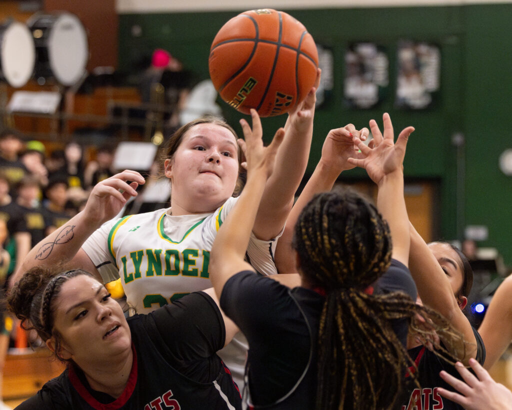 Lynden junior forward Payton Mills tips a rebound away from Archbishop Murphy players.