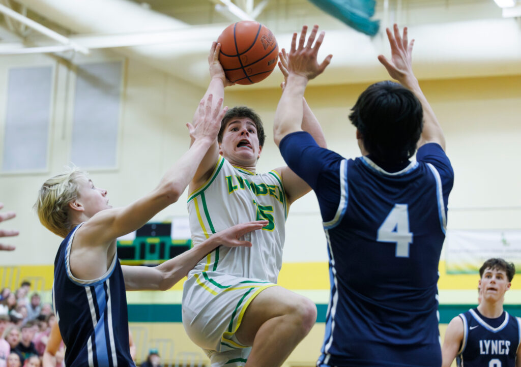 Lynden’s Malachi Koenen shoots under heavy pressure Feb. 1 as the Lions beat Lynden Christian 66-56 at Lynden High. Koenen scored nine crucial points in the second quarter.