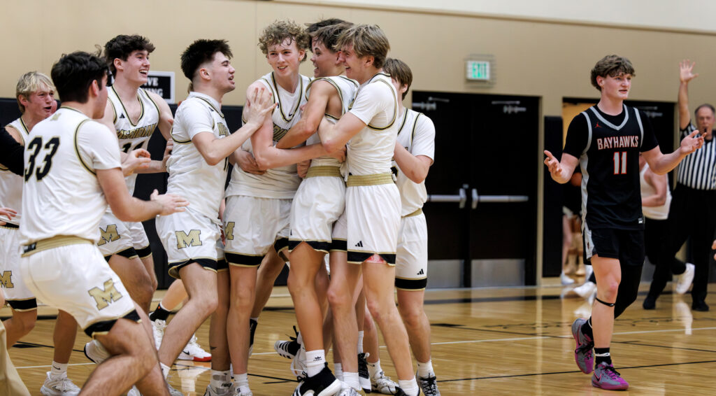 Meridian players pickup Trey Alexander, center,  after his buzzer-beating basket Feb. 7 to give the Trojans an 80-79 win over Bellingham at home.