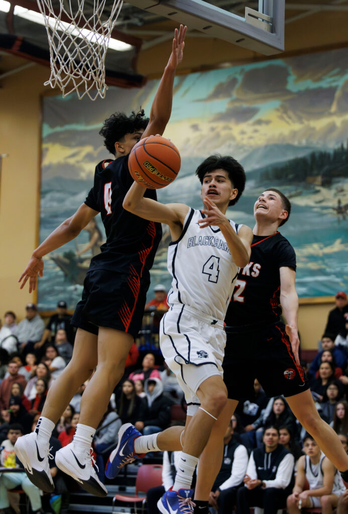 Lummi Nation’s Dyson Edwards throws a pass while driving toward the hoop.